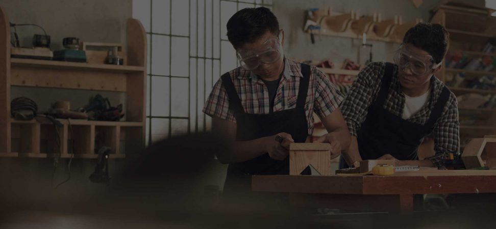 two men crafting a bespoke wooden item in a workshop