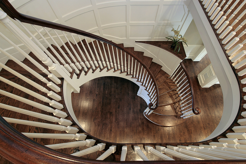 Spiral staircase in luxury home with wood railing